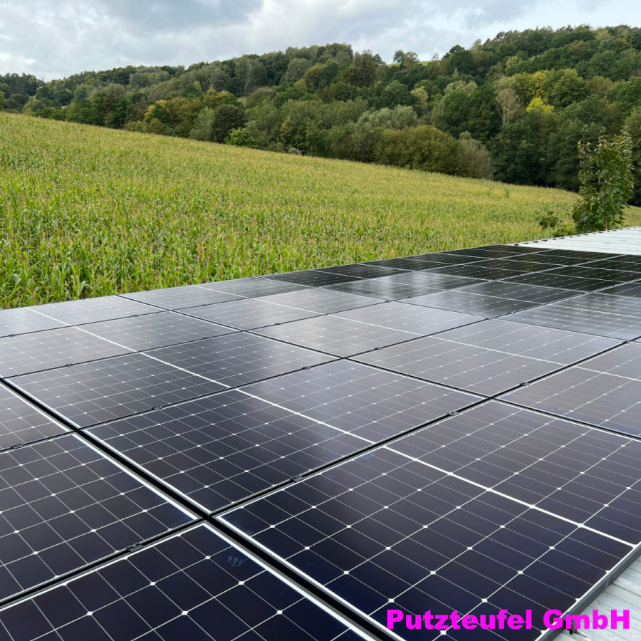 Solaranlage der Putzteufel GmbH auf Dach mit Blick auf grüne Landschaft zur nachhaltigen Energieerzeugung.