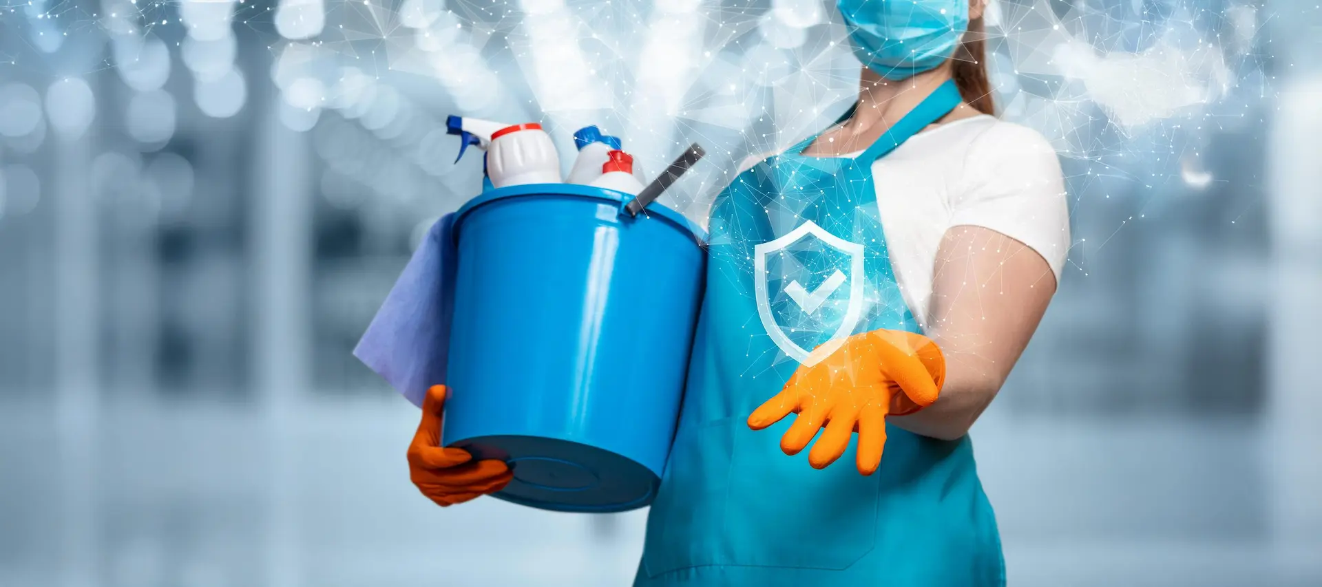 Reinigungskraft mit blauer Schürze und Eimer, trägt Handschuhe und Maske bei der professionellen Gebäudereinigung.